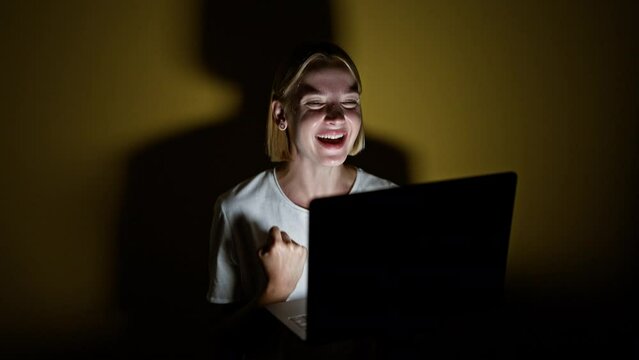 Young blonde woman using laptop celebrating over isolated yellow background