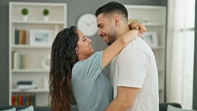 Man and woman couple hugging each other kissing at home