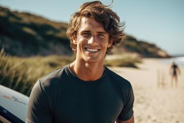 Smiling portrait of a happy male caucasian surfer on a sandy beach