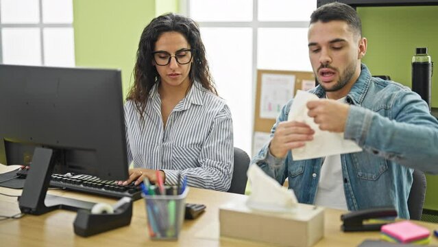 Man and woman business workers using computer sneezing at the office