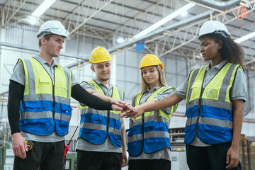 Group of technicians and employees in a paper mill holding hands and talking Collaborate with the team to work in the warehouse.