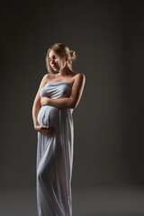 Fototapeta premium Graceful pregnant beautiful woman in greek dress