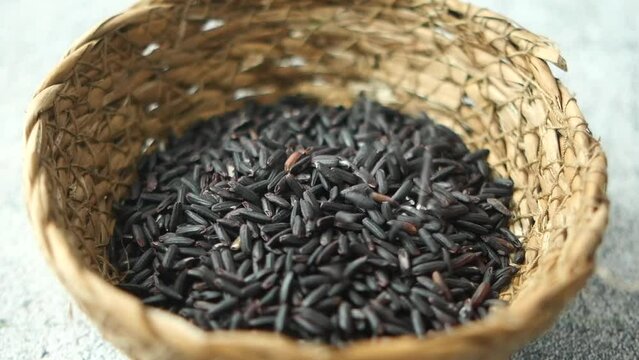 slow motion of Black Rice Grains dropping in bowl on table 