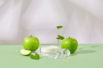 Empty podium in white color arranged with ices and fresh green apples. Minimalist mockup for podium...