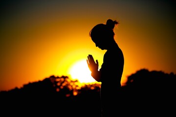 Strong woman raising her hands on sunset background