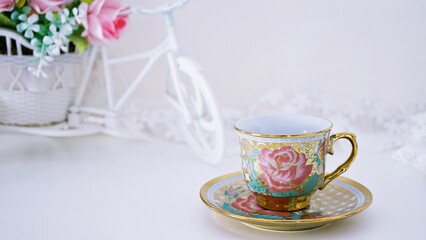 Obraz na płótnie Canvas Antique cup of tea with pink rose on white background ,English tea vintage tone Valentine's day romantic ,Mother's day ,pretty background ,Chinese traditional ,coffee cup ,porcelain teacup 