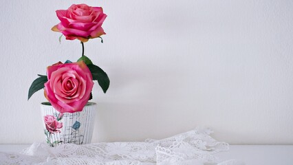 Artificial rose flowers bouquet in vase on table, English classic copy space for text or lettering pretty background or wallpaper ,mother's day ,still life ,women's day festive background ,elegant 