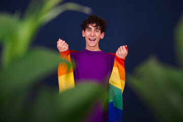 Love and equal rights. Funny curly guy posing with a gay flag.