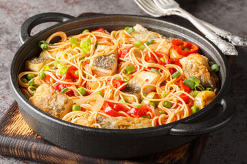Mediterranean food spaghetti with white sea fish, vegetables and tomato sauce close-up in a frying...
