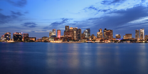 Panoramic view of Boston skyline and harbor at dusk with Atlantic Ocean on the foreground, USA