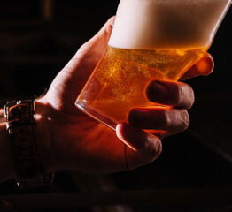 Close-up of barman hand at beer tap pouring a draught lager beer