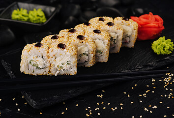 Rolls with cucumbers on a black plate