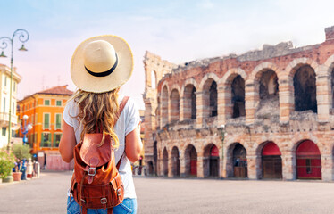 Traveler girl with hat and bag looking at Verona Arena,  tour tourism, travel,vacation in Italy- travel in Europe - obrazy, fototapety, plakaty