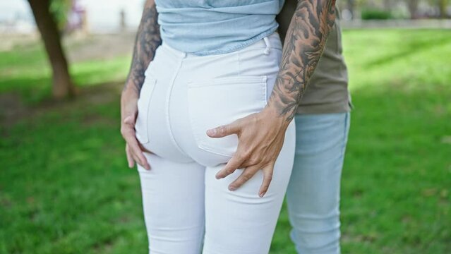 Man and woman couple hugging each other touching ass at park