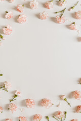 Minimal floral styled concept. Pink carnation flowers on white background with copy space. Creative wedding invitation template. Flat lay, top view