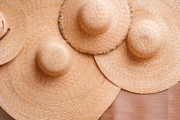 Fototapeta na wymiar Wicker products background of 4 straw floppy hats on woven mat, Top view with copy space