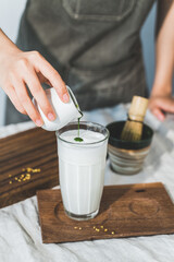 Fototapeta na wymiar Preparation of matcha milk, traditional preparation method, indoor shot, close-up, matcha powder and human hands