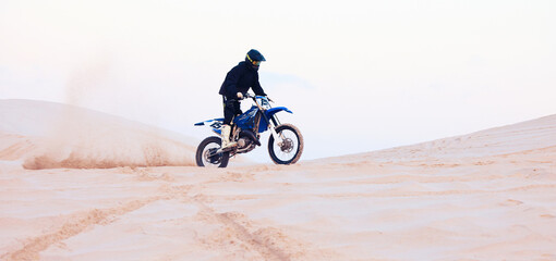 Obraz premium Sand, dust or athlete driving motorcycle for action, adventure or fitness with performance or adrenaline. Desert, sports or person on motorbike on dunes for training, exercise or race or challenge