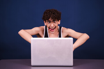Funny curly guy watches an adult video at home. Blue background.