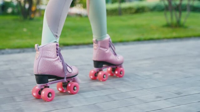 Close up shot of young woman riding quad rollers skates in city. Happy riding retro rollerskates