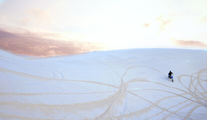 Hill, sand or athlete driving motorcycle for action, adventure or fitness with wellness or adrenaline. Sunset, nature or sports driver on motorbike on dunes in training, exercise or race challenge