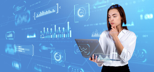 Pensive businesswoman using laptop, graph chart and hologram with indicators