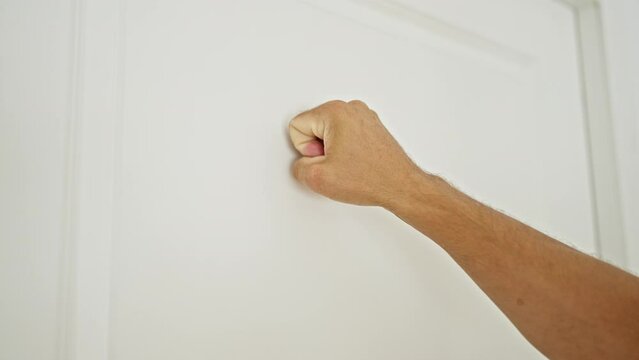 Young hispanic man knocking door at home