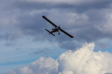 Fototapeta na wymiar Plane flying on cloudy sky from side. Aviation background