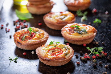 Homemade mini tart with tomatoes and cheese. Vegetarian party food.
