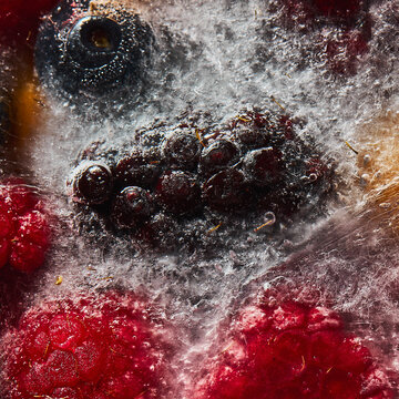 Fresh berries frozen in ice background backdrop colorful raspberry and blueberries
