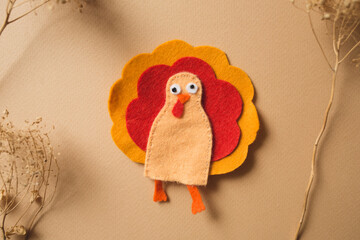 craft for kids. DIY felt finger toy Turkey for thanksgiving day on beige background. create art for children. finger toy
