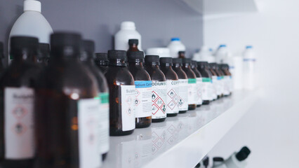 Research, pharmaceutical chemical and bottle on shelf in laboratory with medical warning label,...