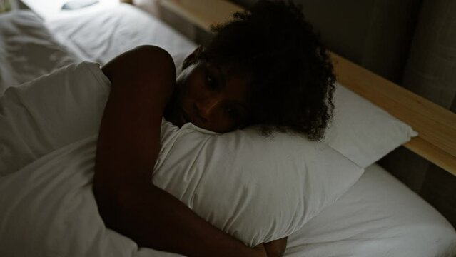African american woman lying on bed suffering insomnia at bedroom