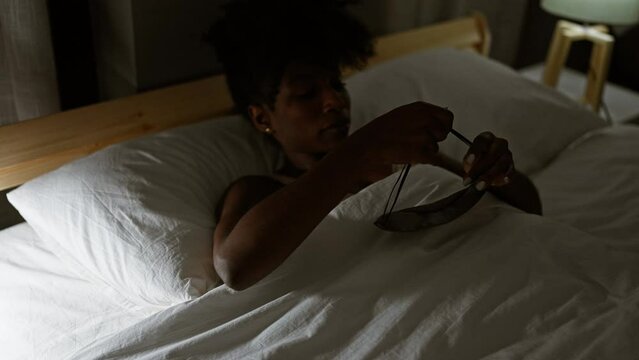 African american woman wearing sleep mask to sleep at bedroom