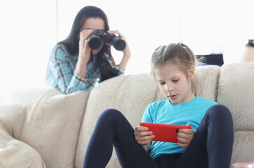 Mom controls her daughter with phone through binoculars. Best parental controls and smartphone apps...
