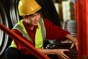 Closeup view of male worker safety hard hat checking product material in factory