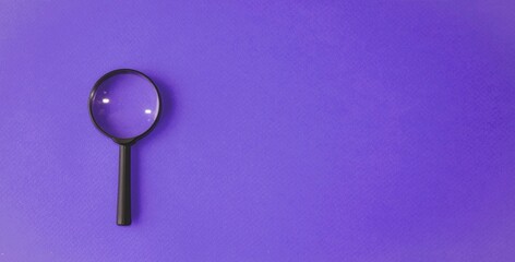 Magnifying glass, magnifying glass in a black frame on a purple, blue background.  Concept research, objects magnification.  Flat top view.  Space for copying text.