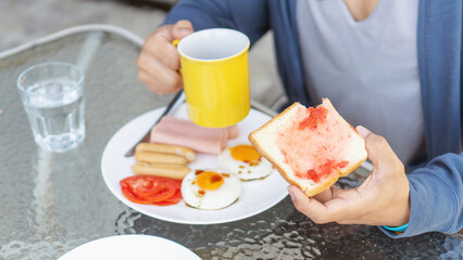 Man eating American breakfast in the morning. - 648459411