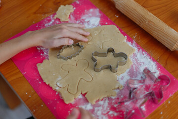 children's hands use cookie cutters when baking dough in the kitchen