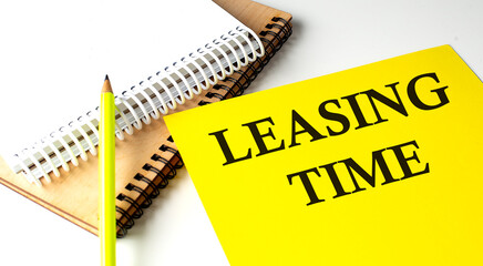 LEASING TIME text written on a yellow paper with notebook