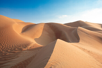 Fototapeta na wymiar Scenic view of the United Arab Emirates desert dunes under a clear blue sky, a travel destination