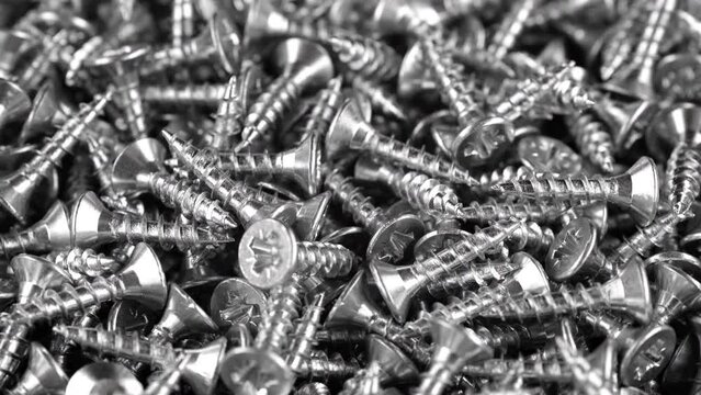 Stainless steel metal screws close up, rotation. Heap of Self-Drilling, self tapping screw