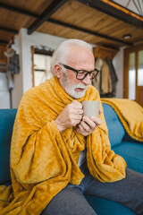 one senior man sit on sofa bed hold cup of tea common cold sneezing