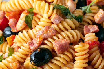 Piatto di pasta con pancetta, sugo e olive nere, cibo italiano 