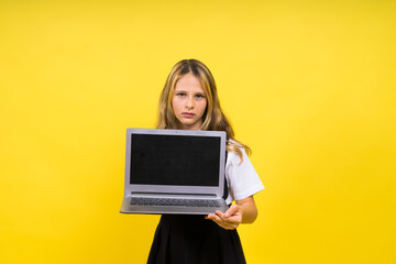 Little happy blonde kid girl 12-13 years laptop pc computer. Children lifestyle childhood concept.