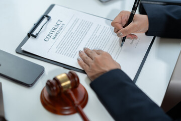 female lawyer Muslim wearing hijab working on business contract documents with laptop and reading law book Take notes to check the accuracy of justice. Legal services concept in the office.