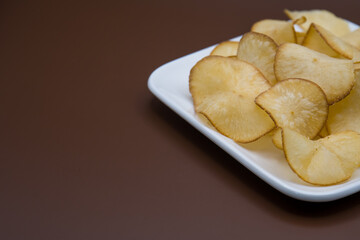 cassava chips isolated on brown background