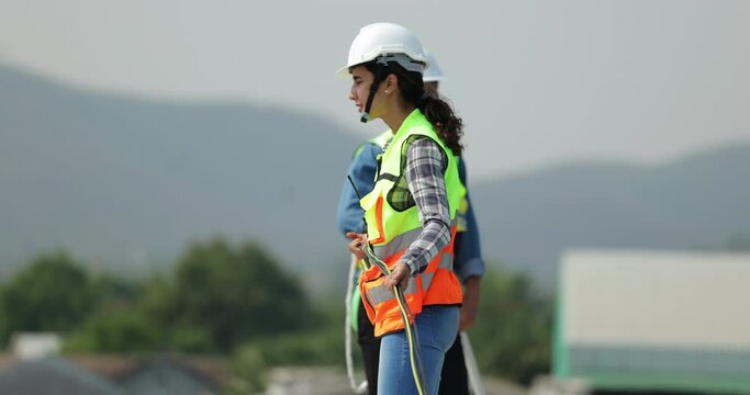 Slow motion video. Electrician pulling wire into PVC  pipe electrical engineering female Installing Solar Cell panels on Roof. Solar energy clean and green alternative energy concept.