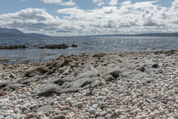 Magnificent shiney slate pavement on a stoney beach in Kintyre