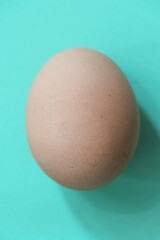 Egg on the cyan background in center. Design, visual art, close up, top view.